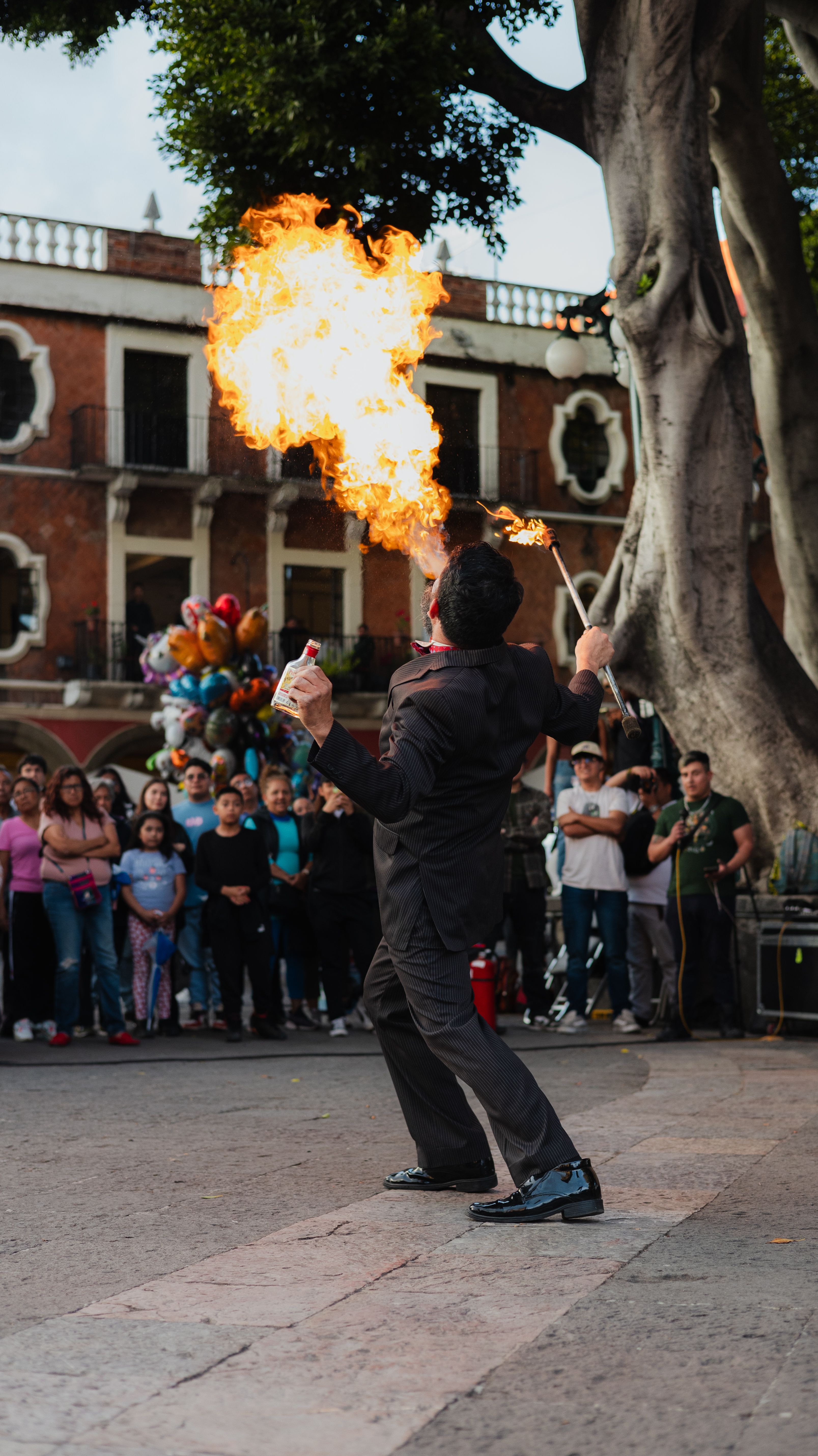 Mago escupefuego actuando en la plaza de un pueblo ante el público