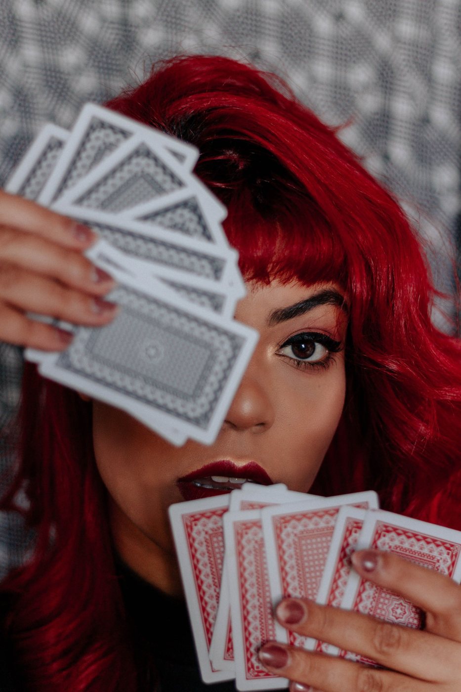 Maga con cartas ante un fondo gris